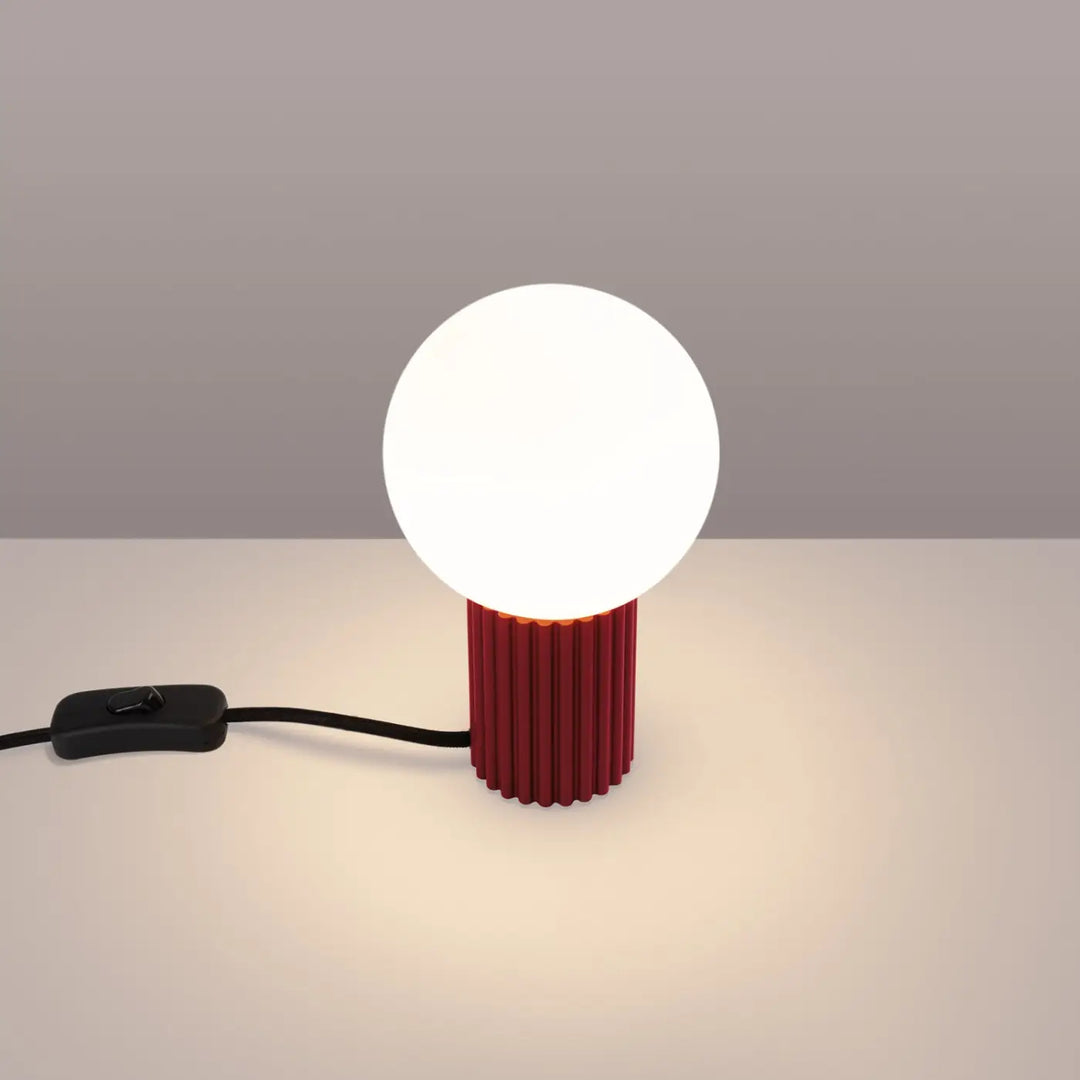 Lampe à poser bordeaux allumée