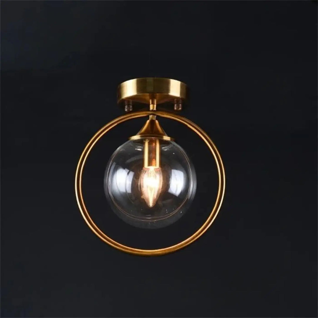 Luminaire plafonnier orbane anneau doré avec boule lumineuse en verre clair et ampoule filament exposé plafond chic