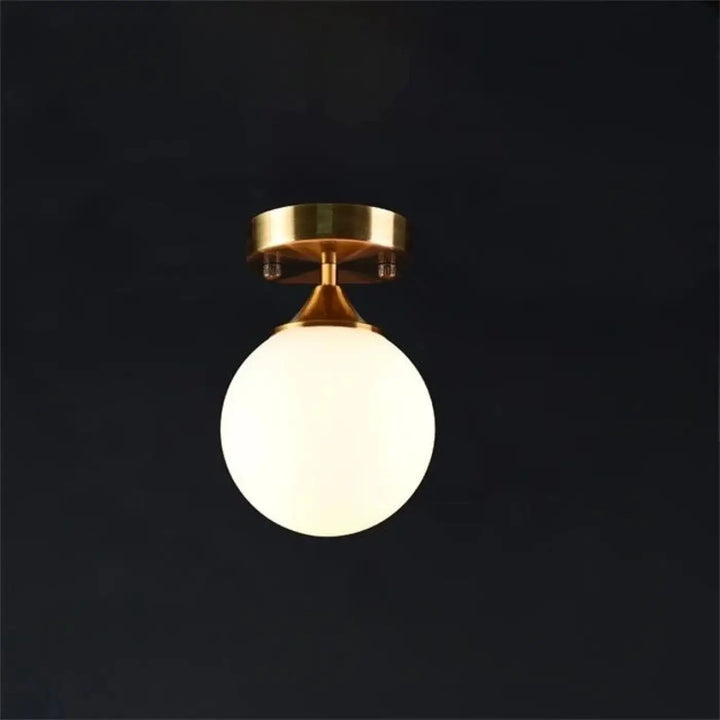 Plafonnier chic orbane avec finition laiton anneau doré et boule lumineuse en verre blanc dépoli