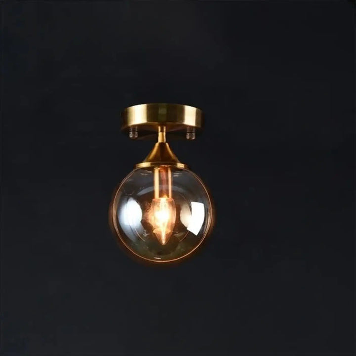 Luminaire plafonnier orbane avec anneau doré et boule lumineuse en verre sphérique finition laiton avec ampoule ton chaud