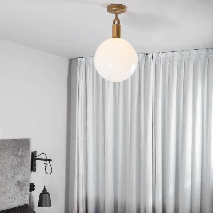 Plafonnier Forked Large à globe opale, finition laiton, dans un intérieur #couleur_dor