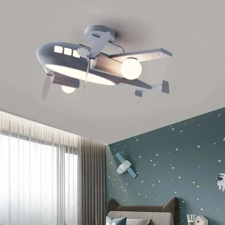 Luminaire plafonnier aeris gris en forme davion avec hélice et fenêtres de cockpit diffuse une lumière chaude idéale pour chambre à coucher