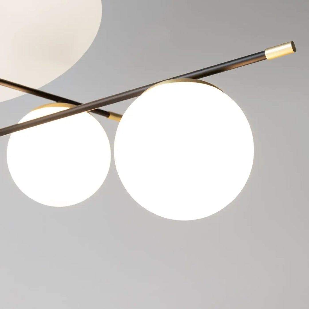 Plafonnier nostalgia xxl moderne minimaliste avec deux globes en verre blanc lumineux suspendus par tiges noires et détails dorés