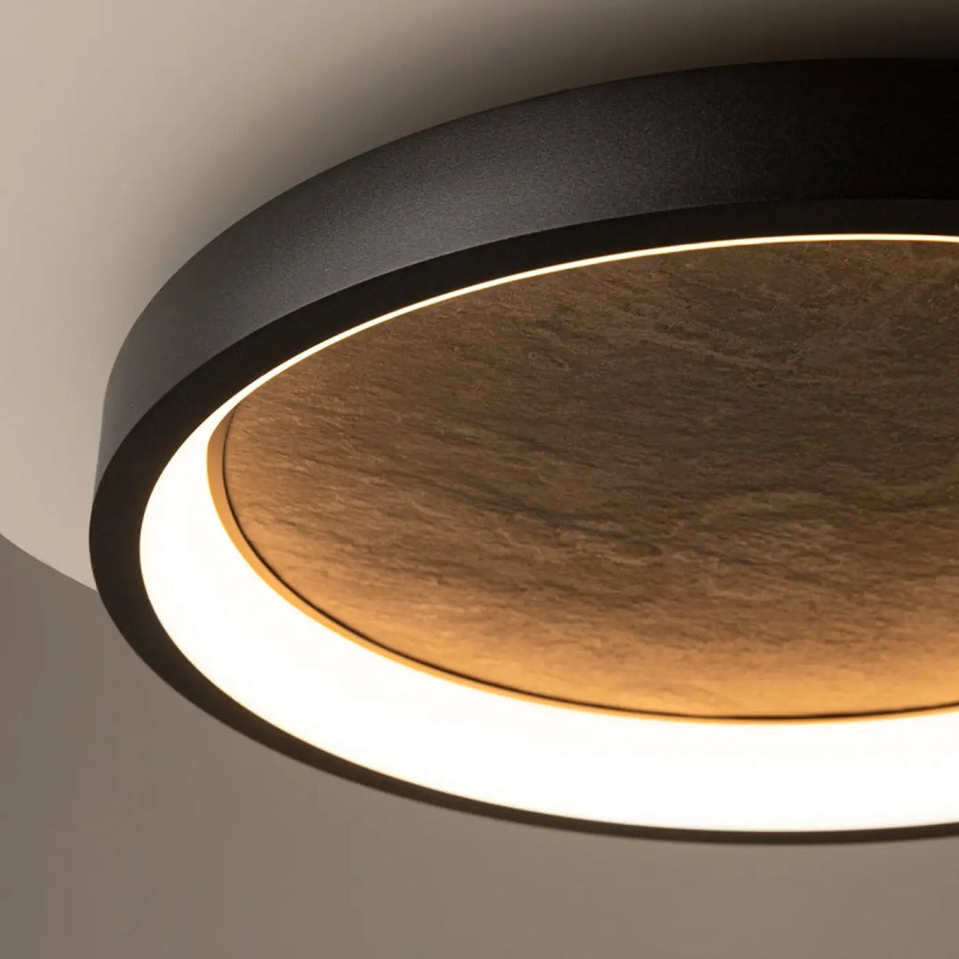 Plafonnier orign avec effet pierre en centre texturé pierreux et cadre noir mat diffusant une lumière chaude douce