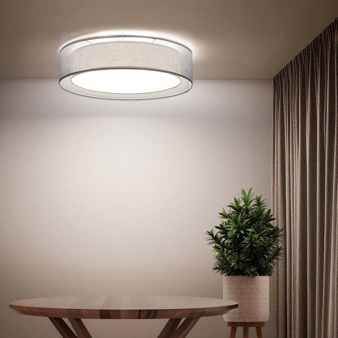 Plafonnier rond bleu clair luminaire puRO avec abat-jour en tissu gris et bord métallique émettant une lumière blanche chaude