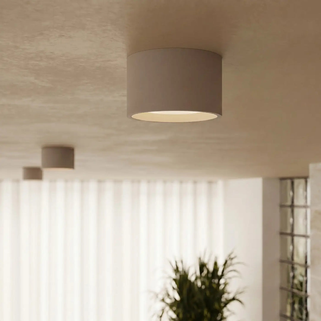 Plafonnier rond plat taupe allumé, vue rapprochée