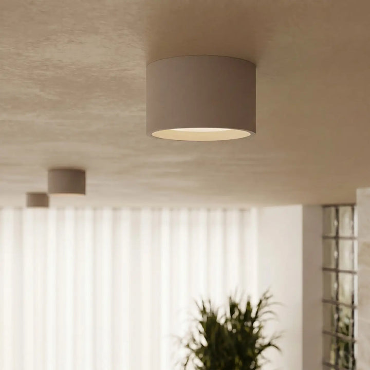 Plafonnier rond plat taupe allumé, vue rapprochée