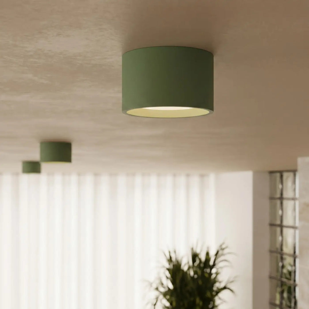 Plafonnier rond plat vert olive allumé, vue rapprochée