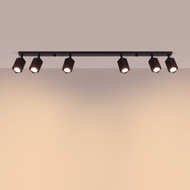 Plafonnier Rayo noir en rampe à spots orientables, allumé