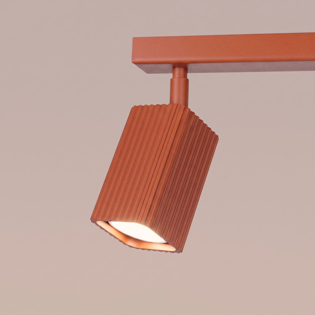 Plafonnier Rayo ocre rouge en rampe à spots orientables, détail des cannelures