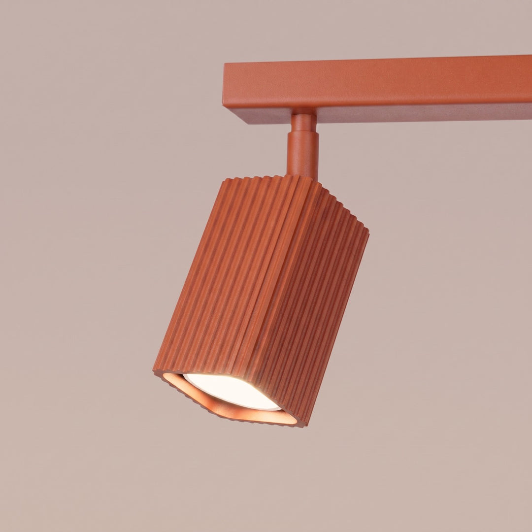 Plafonnier Rayo ocre rouge en rampe à spots orientables, détail des cannelures