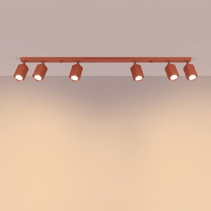 Plafonnier Rayo ocre rouge en rampe à spots orientables, allumé