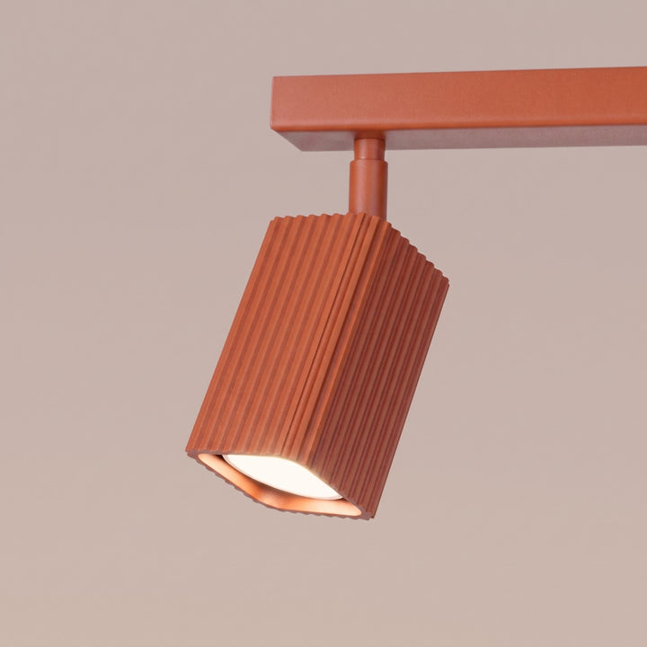 Plafonnier Rayo ocre rouge en rampe à spots orientables, détail des cannelures