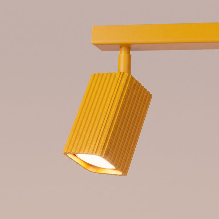 Plafonnier Rayo jaune en rampe à spots orientables, détail des cannelures