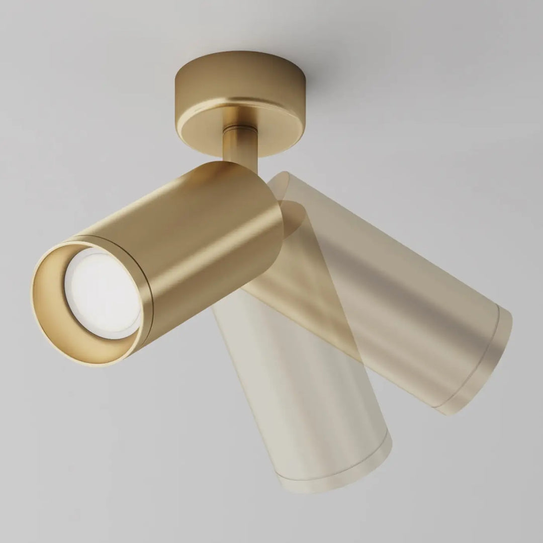 Spot directionnel à base ronde en laiton avec deux bras cylindriques ajustables pour un éclairage focus moderne