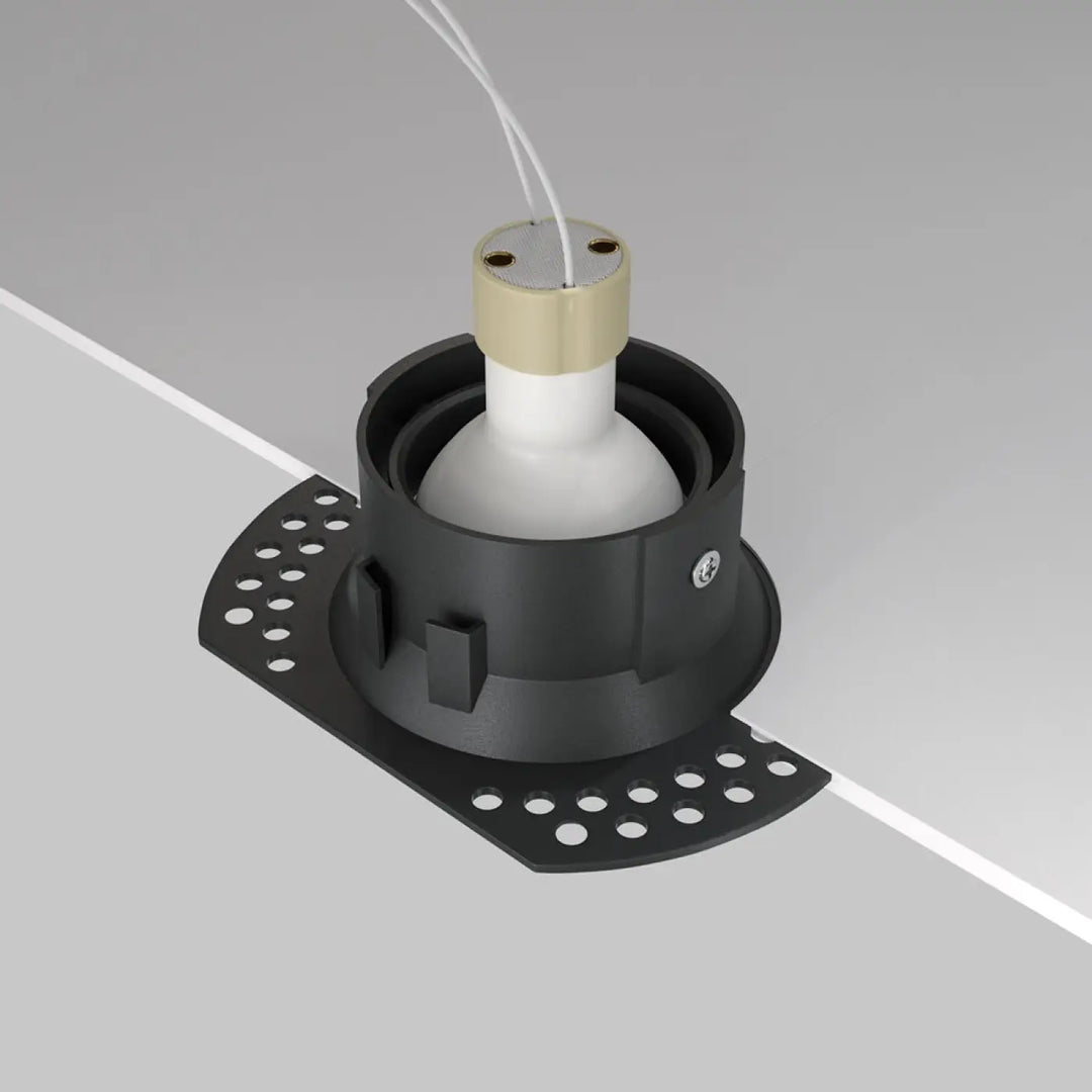Spot encastrable dot avec finition mate noire, base perforée circulaire et ampoule blanche dans collier doré