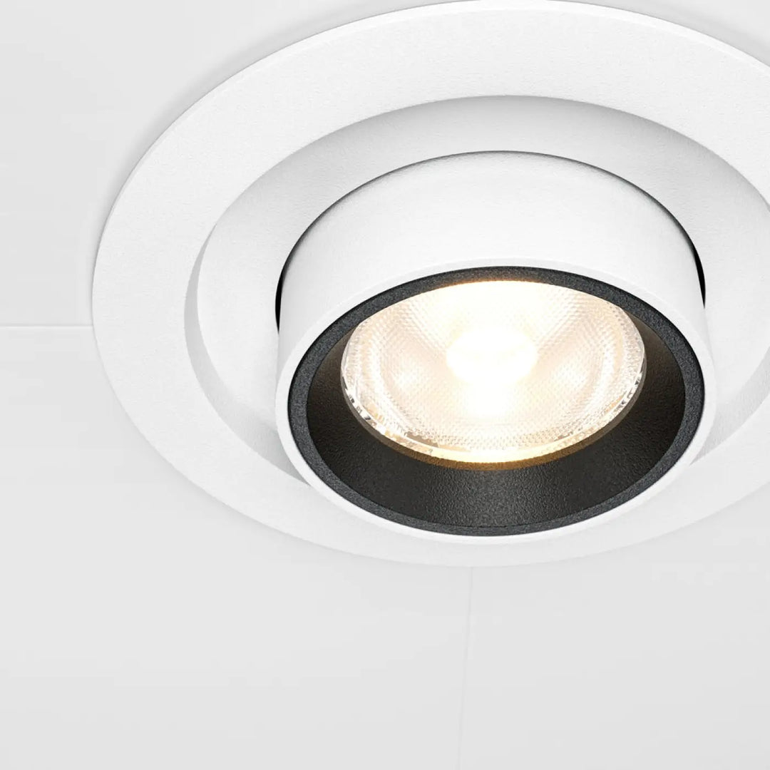 Spot hidden led rétractable en acier noir avec design moderne de cercles concentriques encastré au plafond blanc et noir