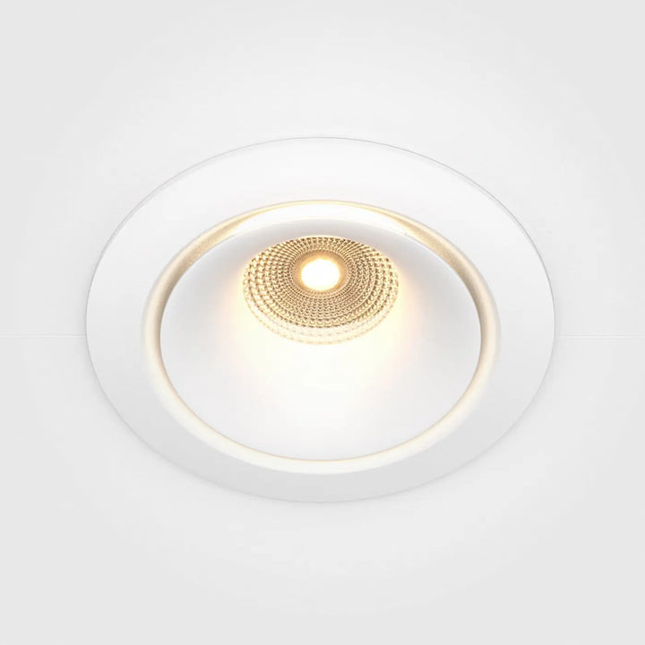 Spot yin led intégrée blanc chaud avec centre circulaire texturé doré émettant une lumière chaleureuse encastrée