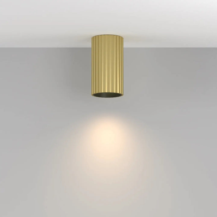 Spot calipso cylindre cannelé doré avec éclairage ciblé chaud et trois finitions disponibles pour plafond encastré