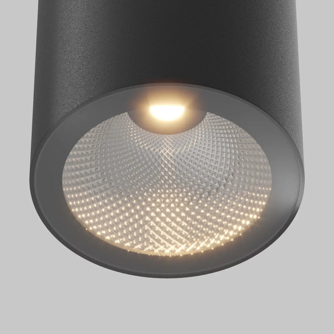 Spot roll cylindre noir en acier noir avec finition mate texturée et verre diffusé à motif émettant une lumière chaude