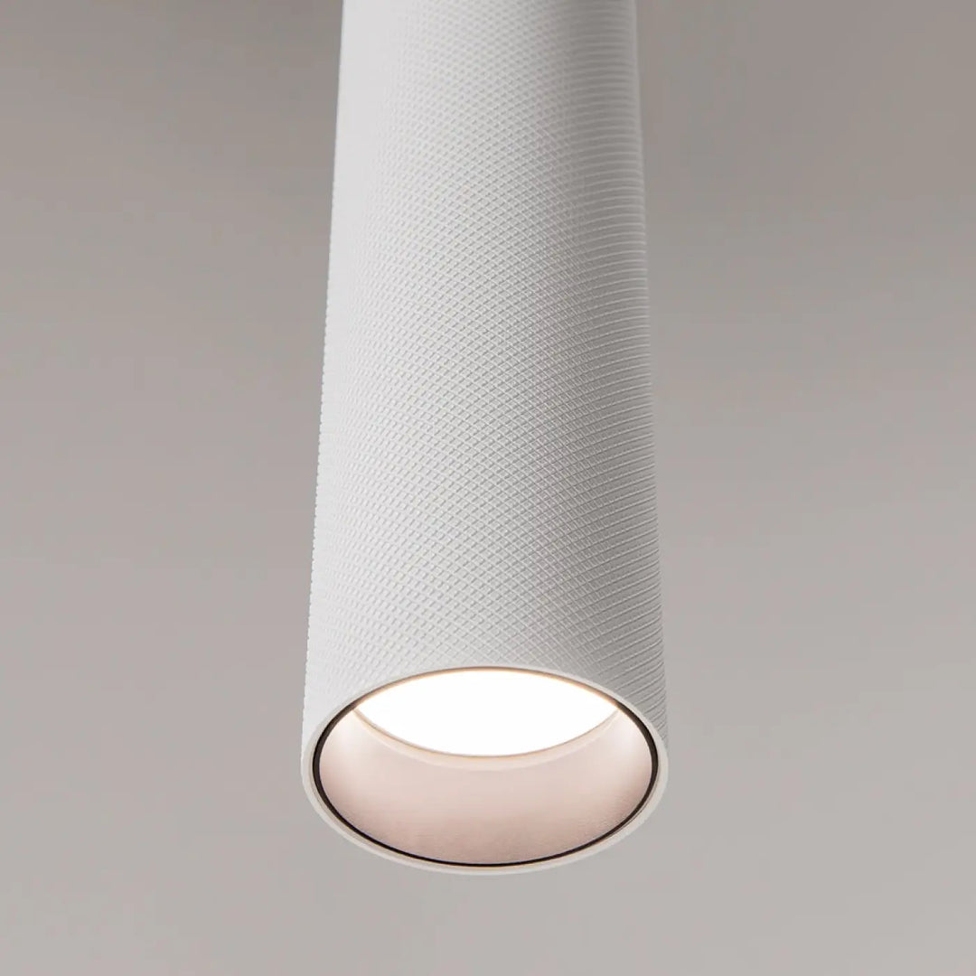 Suspension artisan blanche cylindrique avec surface texturée et ouverture lumineuse, idéale au-dessus d’une table