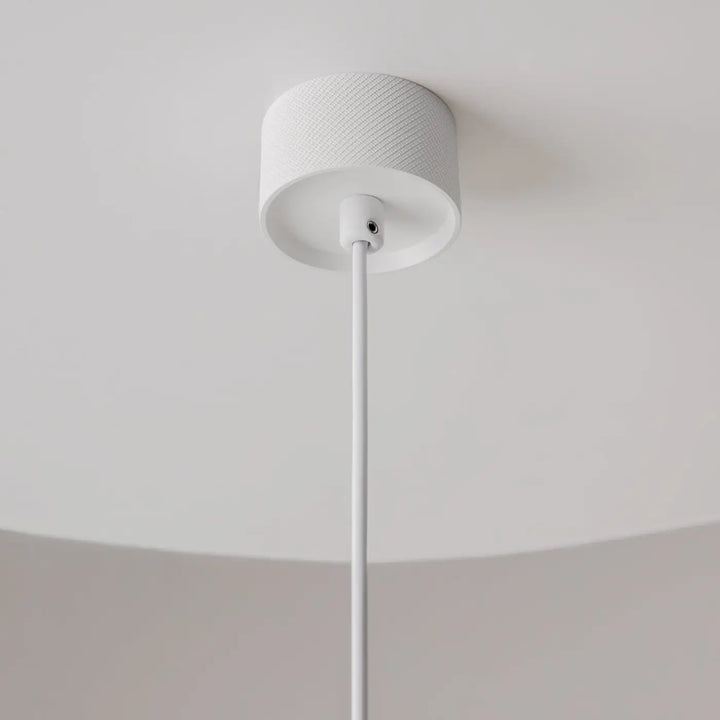 Suspension artisan blanche cylindrique avec couverture en tissu texturé et tige metalique pour au-dessus d’une table