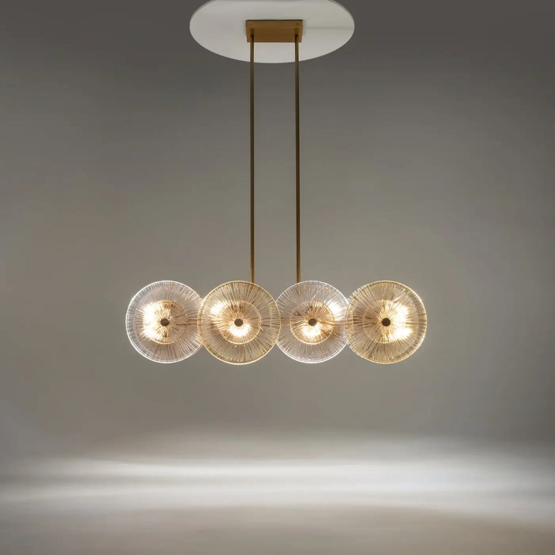 Suspension aster avec monture dorée et quatre abat-jour en verre ambré à motifs rayonnants gravés