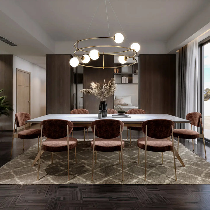 Suspension balance avec verre opale suspendue au-dessus dune table blanche moderne entourée de chaises velours bordeaux aux arches dorées