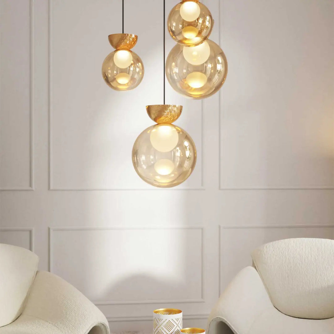 Suspension charm avec globe lumineux doré en verre sablé et fixation métallique accroché au plafond