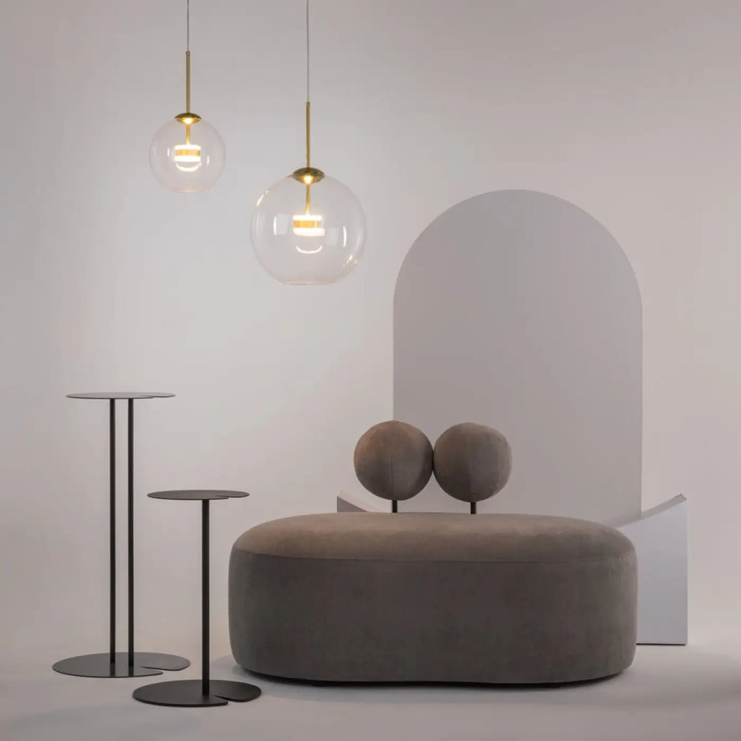 Suspension cometa en verre soufflé suspendue au-dessus d’une table avec ottoman moderne en velours gris et coussins sphériques