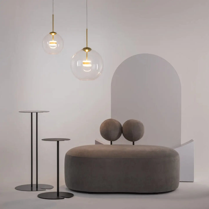 Suspension cometa en verre soufflé suspendue au-dessus d’une table avec ottoman moderne en velours gris et coussins sphériques