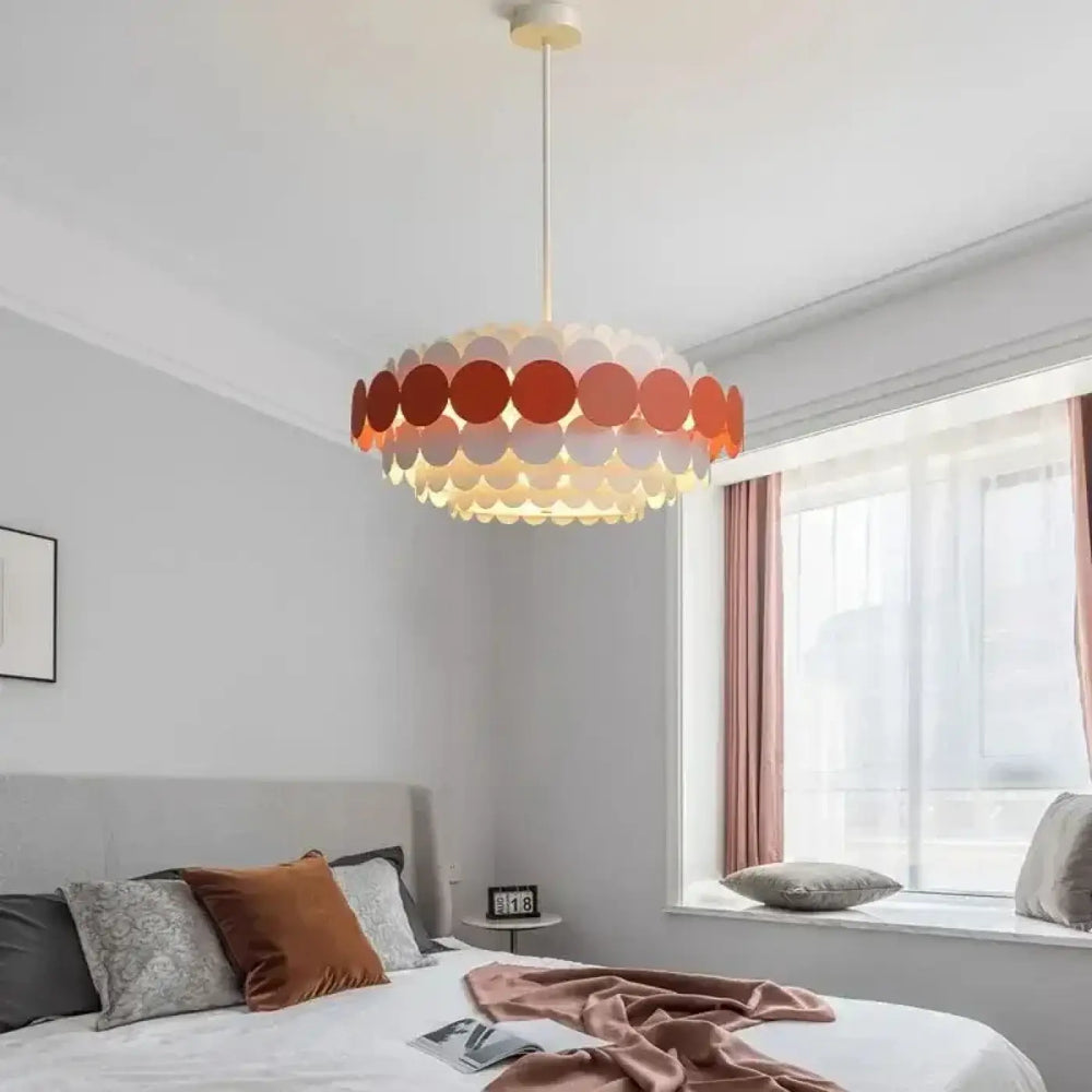 Suspension luminaire calou avec disque translucide orange et blanc conçu comme un chandelier de plafond minimaliste