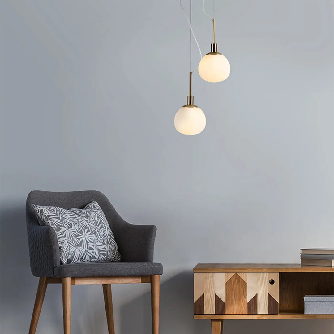 Deux suspensions luminaire erich avec globe en verre soufflé et finition laiton dans un style art déco pour lumière douce