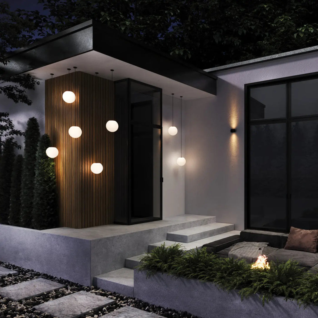 Suspension extérieure erda globe opalin avec monture noire et lumière blanche chaude pour entrée minimaliste