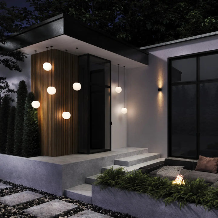 Suspension extérieure erda globe opalin avec monture noire et lumière blanche chaude pour entrée minimaliste