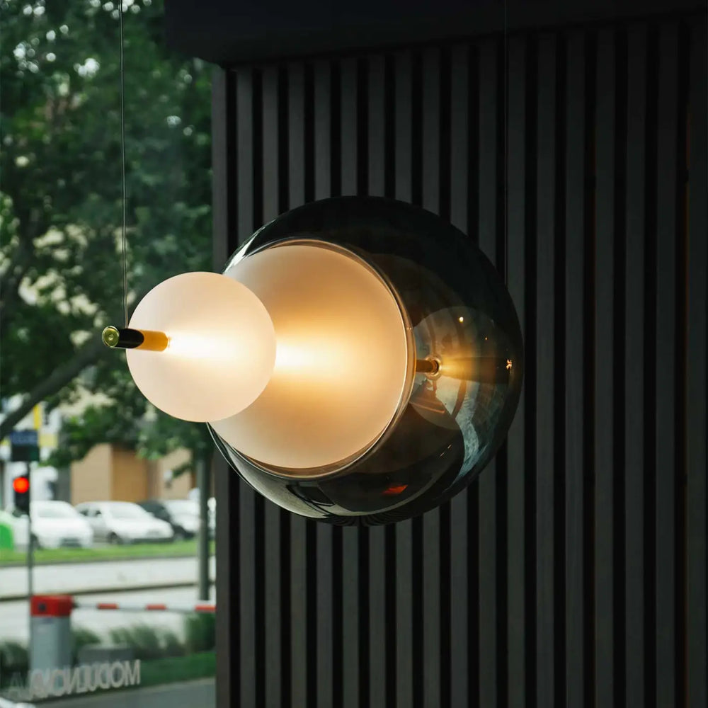 Suspension luminaire galileo avec globe intérieur blanc opaque, sphère extérieure noire en verre et finitions laiton
