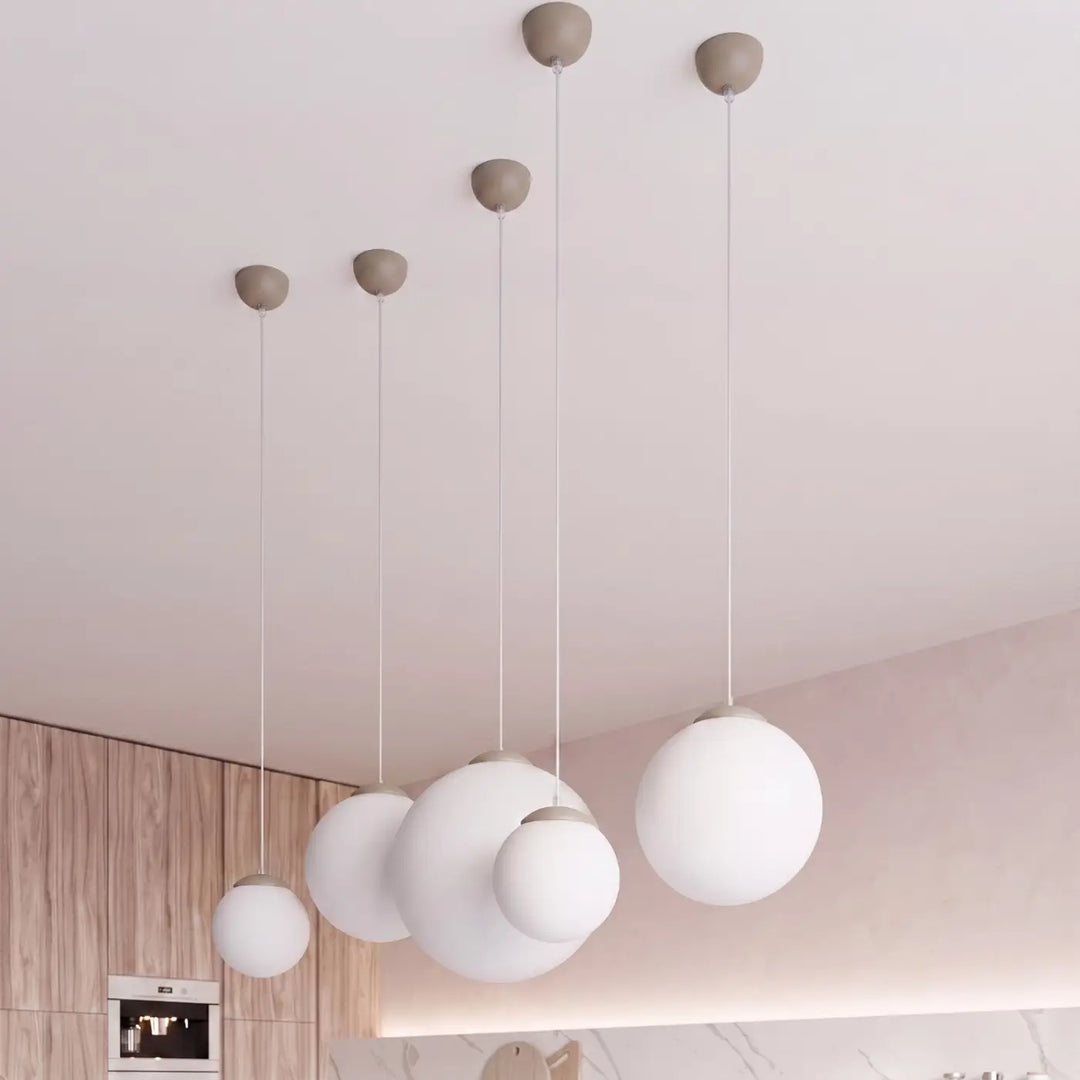 Suspension Ugo à globe en verre blanc et monture taupe dans un intérieur contemporain