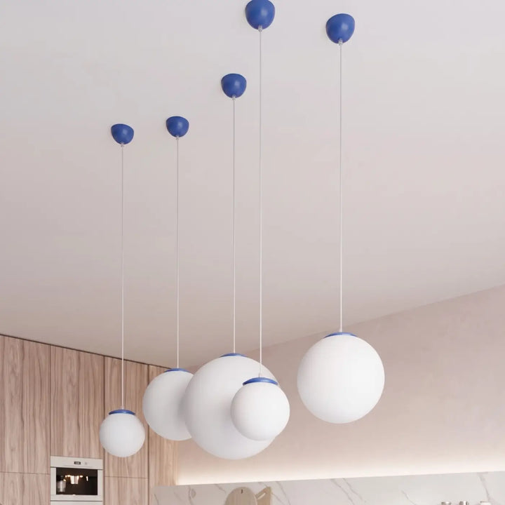 Suspension Ugo à globe en verre blanc et monture outremer dans un intérieur contemporain