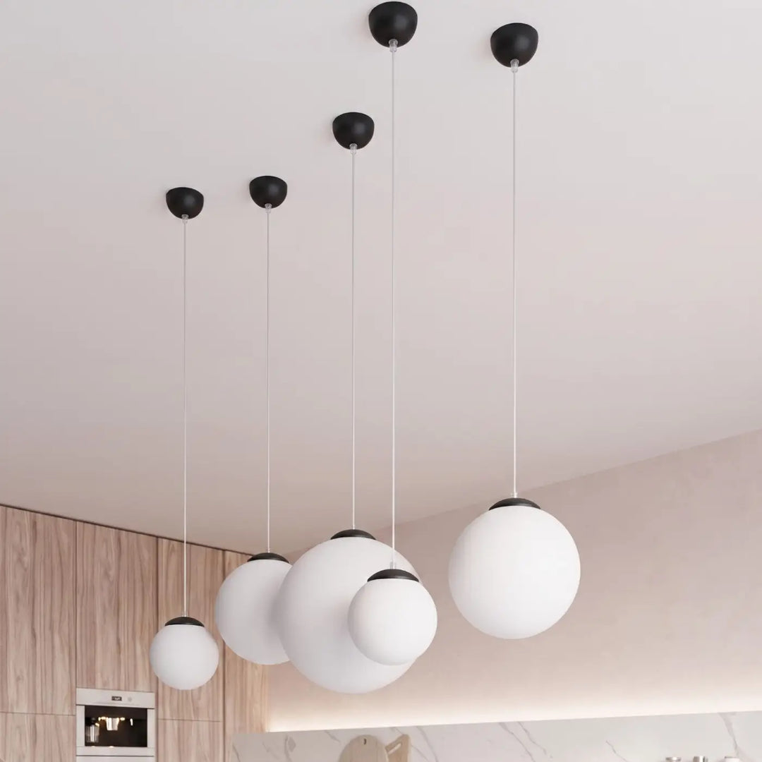 Suspension Ugo à globe en verre blanc et monture noire dans un intérieur contemporain