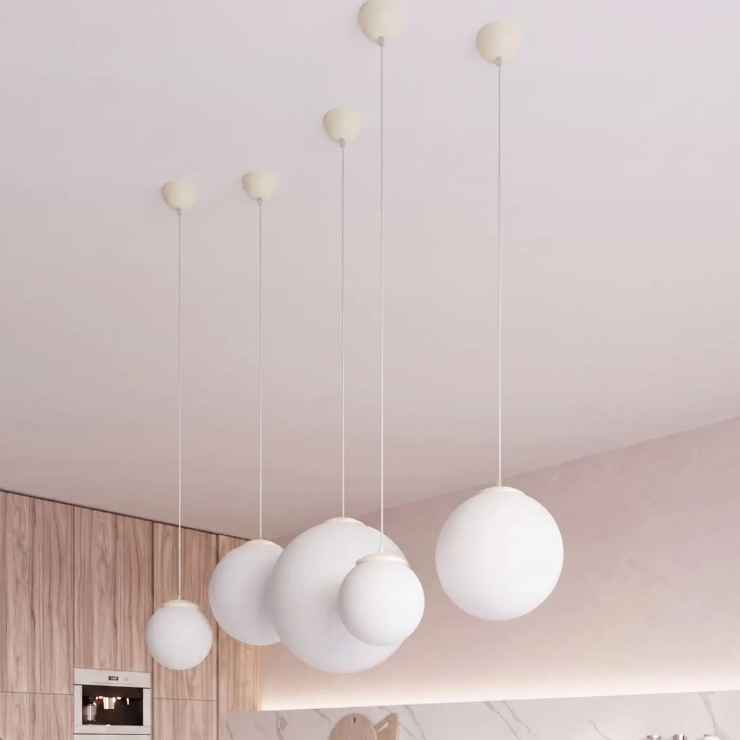 Suspension Ugo à globe en verre blanc et monture beige dans un intérieur contemporain