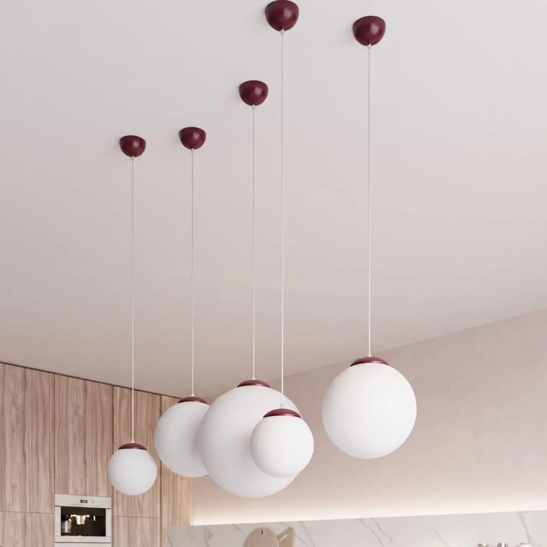 Suspension Ugo à globe en verre blanc et monture bordeaux dans un intérieur contemporain