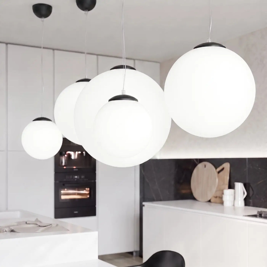 Suspension Ugo à globe en verre blanc et monture noire dans un intérieur contemporain
