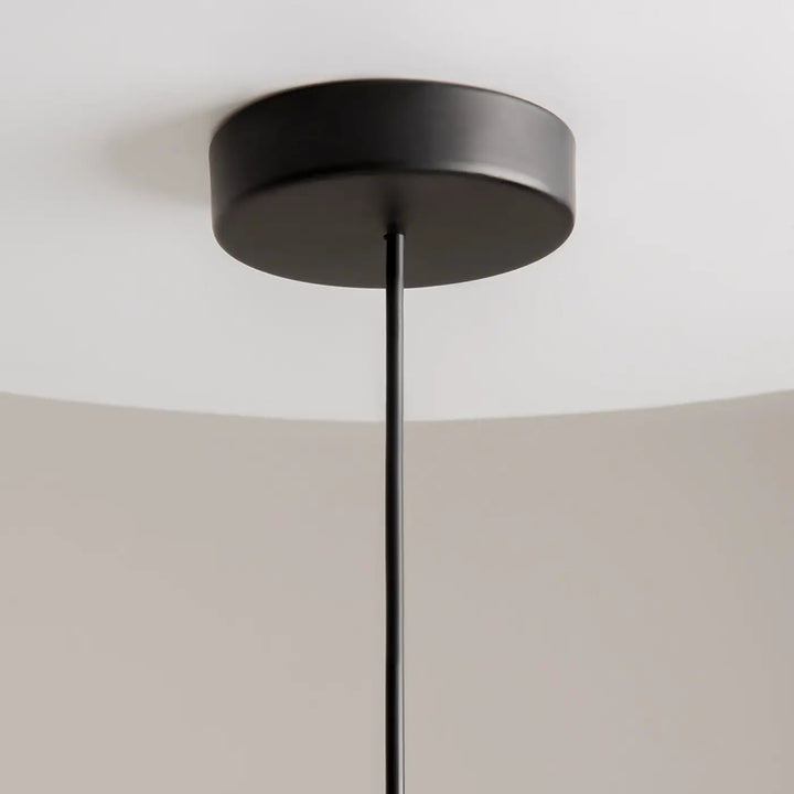 Suspension kyoto cylindre en finition mate noire avec base circulaire élégante et tige fine pour lumière douce