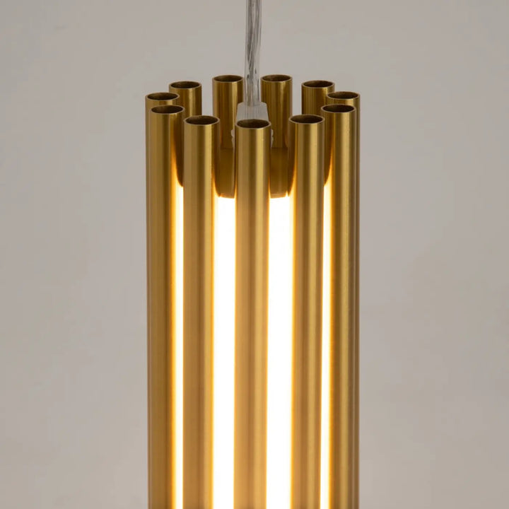 Suspension luminaire sonata cylindre en acier doré avec tubes verticaux et suspension led intégrée au-dessus d’un îlot