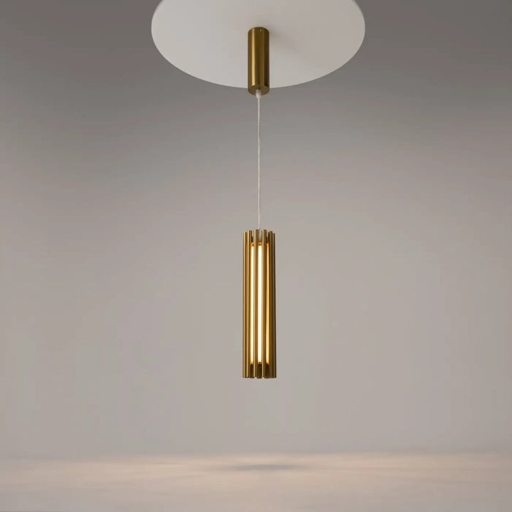 Suspension luminaire sonata en acier doré cylindrique au-dessus d’un îlot avec suspension led moderne