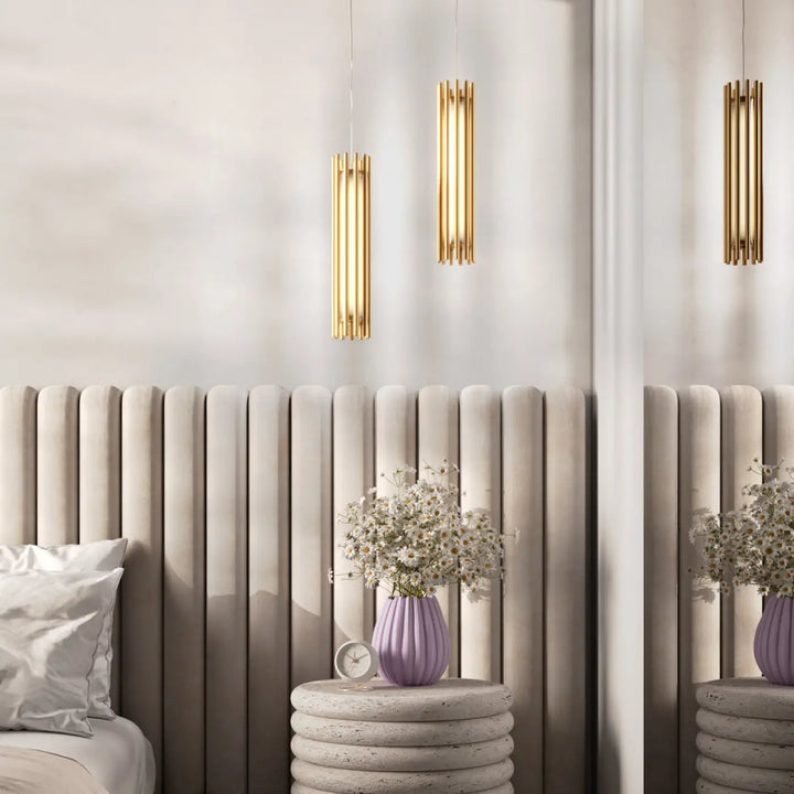 Suspension luminaire sonata cylindre en acier doré avec vase céramique violet au-dessus d’un îlot avec suspension led