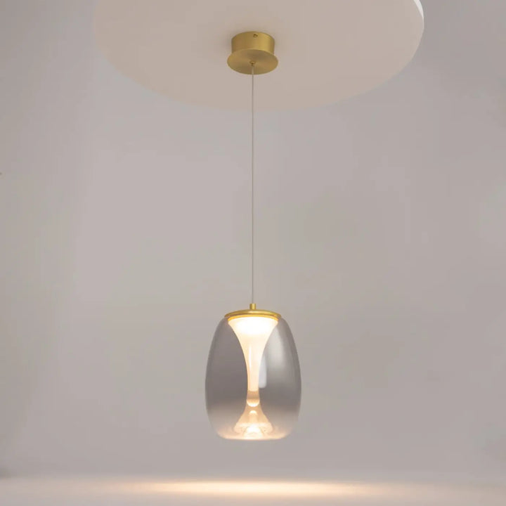 Suspension luminaire splash led avec abat-jour en verre translucide et accents métalliques dorés au-dessus d’un îlot