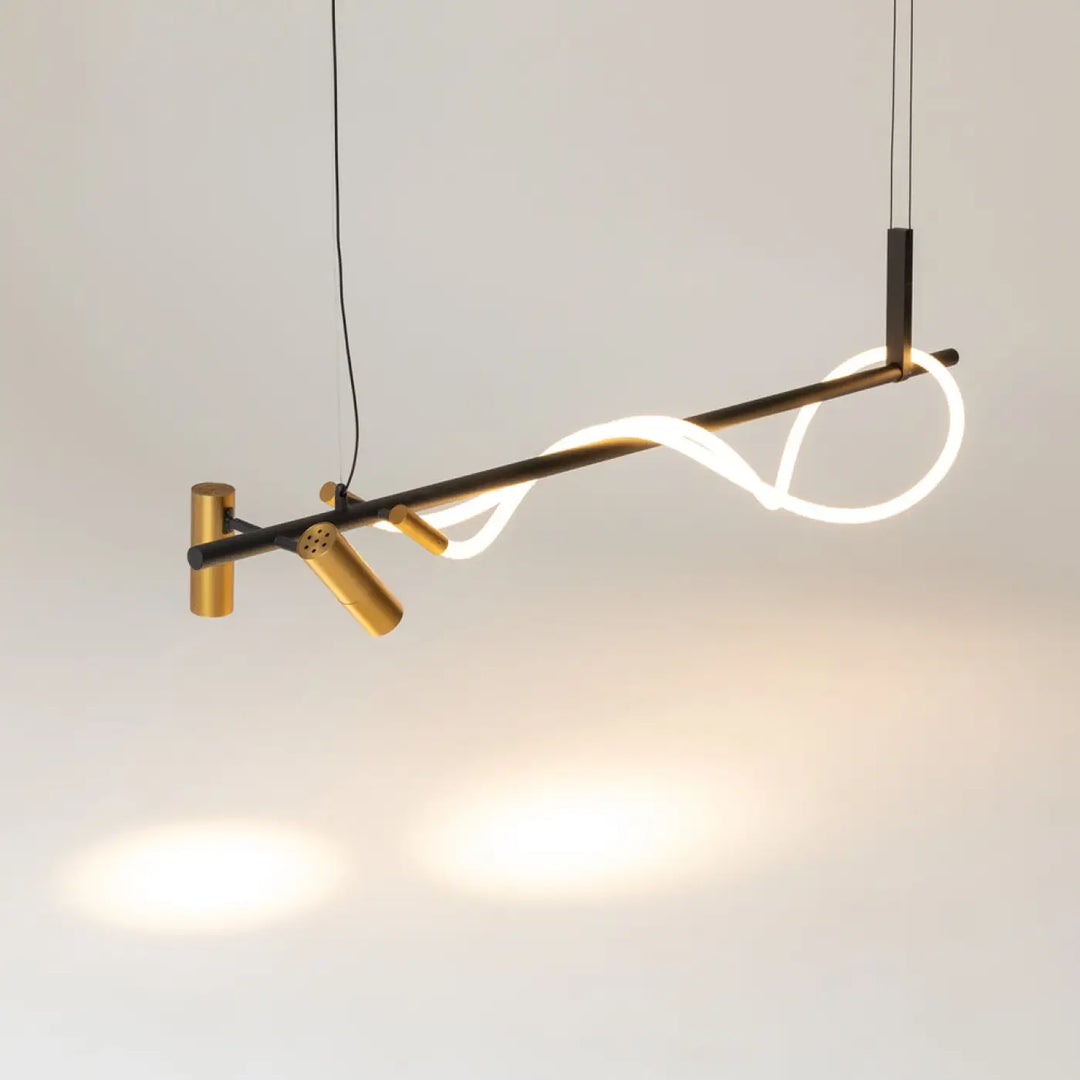 Suspension led tau ruban noué en acier noir avec cadre métal noir et doré et bande led blanche au-dessus d’une pièce