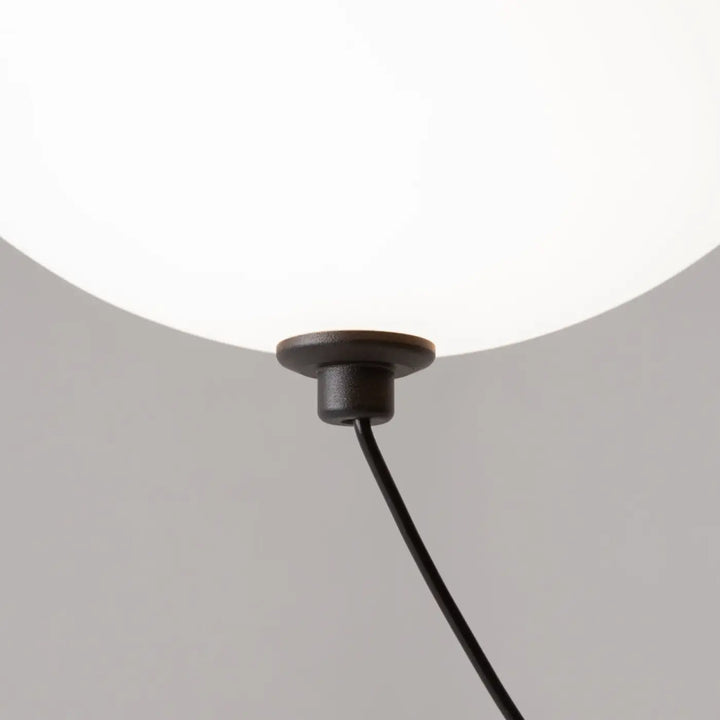 Suspension luminaire twiNS avec base noire mate cylindrique et globe en verre dépoli blanc pour suspension led trois globes au-dessus d’une table
