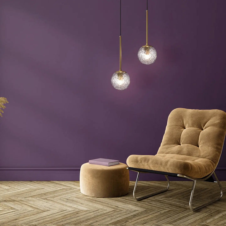 Deux suspensions luminaire ligero avec monture dorée et globes en verre transparent texturé dans un style art déco